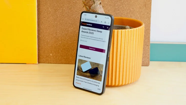 CMF Phone 2 Pro leaning against a plant pot, display showing the Expert Reviews homepage