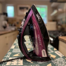 Tefal Ultimate Pure FV9830 steam iron review standing side view on a colourful ironing board