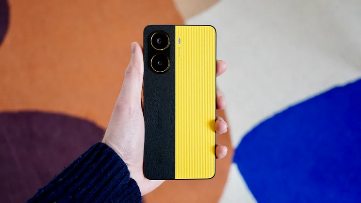 Xiaomi Poco X7 Pro in hand, rear view, in front of a multi-coloured rug