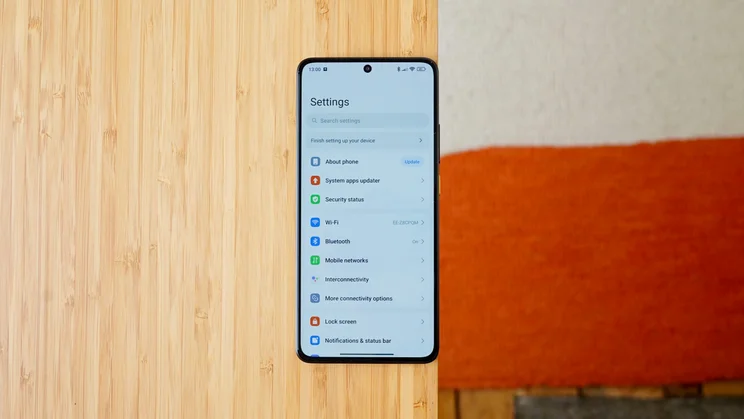 Xiaomi Poco X7 Pro face down on the edge of a table, display showing the settings screen