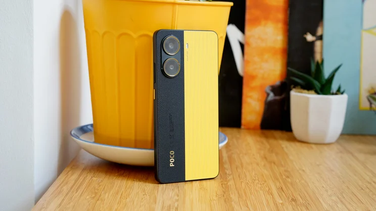Xiaomi Poco X7 Pro leaning against a yellow pot, rear view