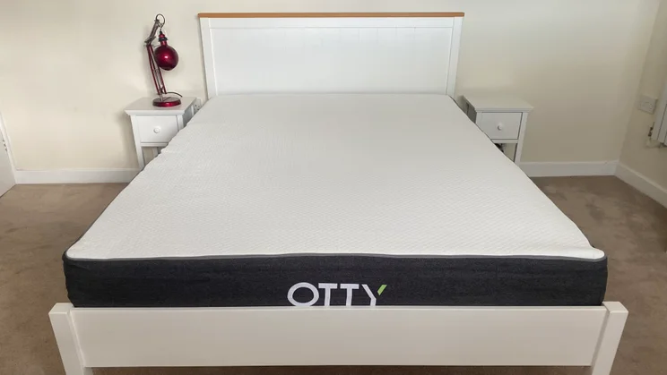 Otty Original Hybrid mattress on a wooden bed frame, in a bedroom