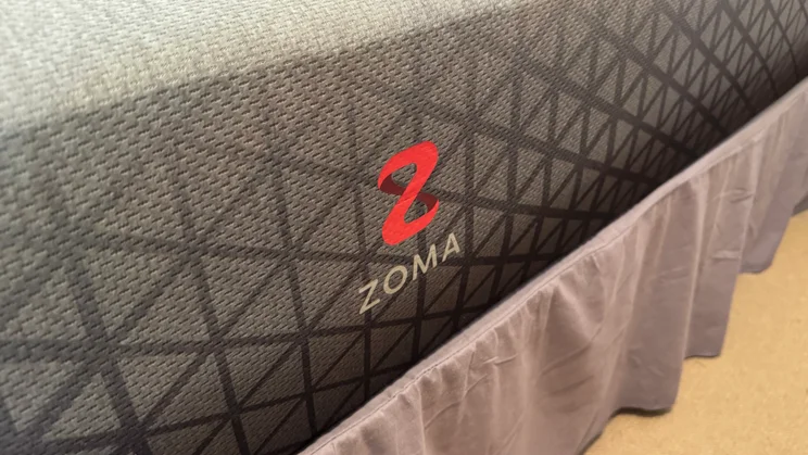 A close up of the Zoma mattress logo