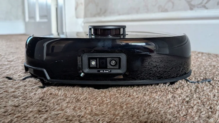 A photograph of the front of the Eufy E25 robot vacuum cleaner on a brown carpet
