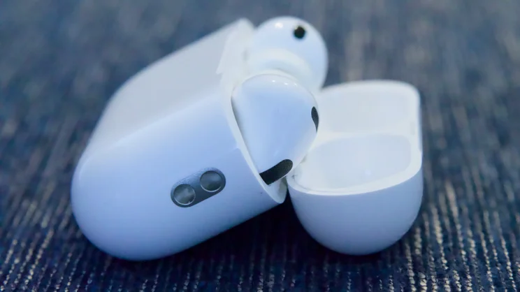 The Apple AirPods Pro 3 shown open from the right side resting on blue textile