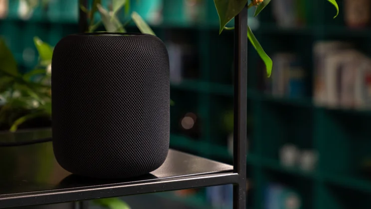 The Apple HomePod 2 on a shelf next to a house plant