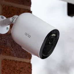 The Arlo Go 2 security camera mounted on a red brick exterior wall