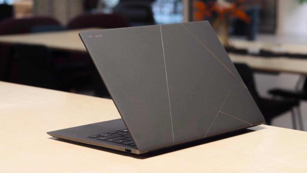 Asus Zenbook S 14 pictured on a wood table in an office environment