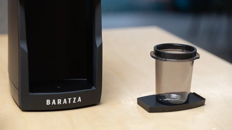 The Baratza Encore ESP Pro coffee grinder on a kitchen surface, with single dose cup next to it