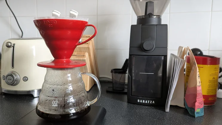 Pour over coffee brewing in a V60 on a kitchen worktop, with Baratza Encore ESP Pro coffee grinder in the background