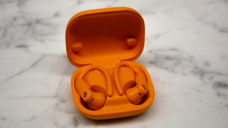 Beats Powerbeats Pro 2 in their case, open, on a white countertop