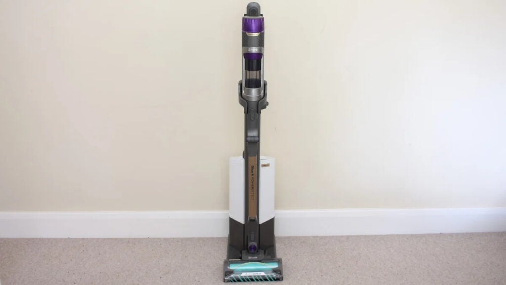 The Shark PowerDetect Clean and Empty in front of a plain white wall