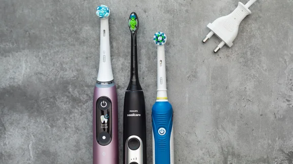 best electric toothbrush lead image: oral-b and phillips sonicare toothbrushes on grey background with charger