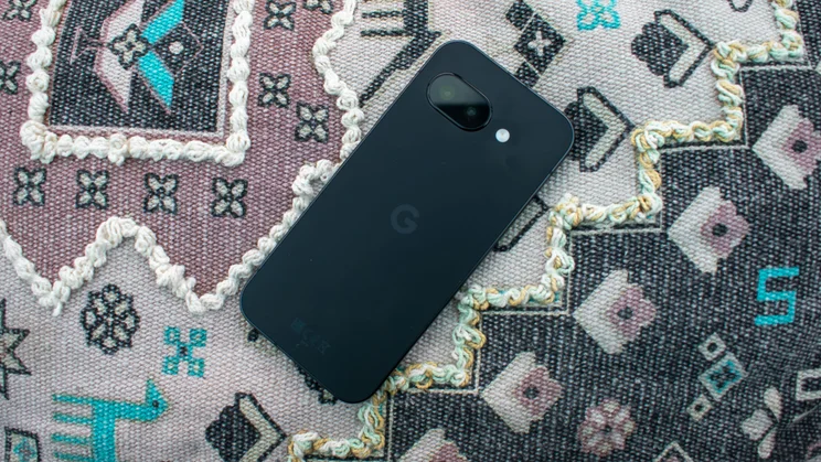 Google Pixel 9a face down on a patterned cushion