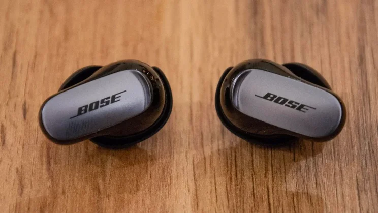 best wireless earbuds Bose QuietComfort Ultra on a wooden worktop