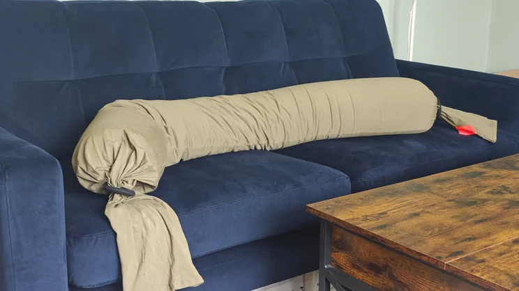 The bbhugme pregnancy pillow on a dark blue sofa