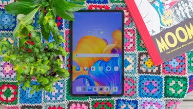 Best tablet - Honor Pad 8 sat on a blanket with a plant and book
