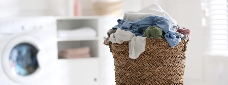 Laundry basket full of dry clothes in a laundry room