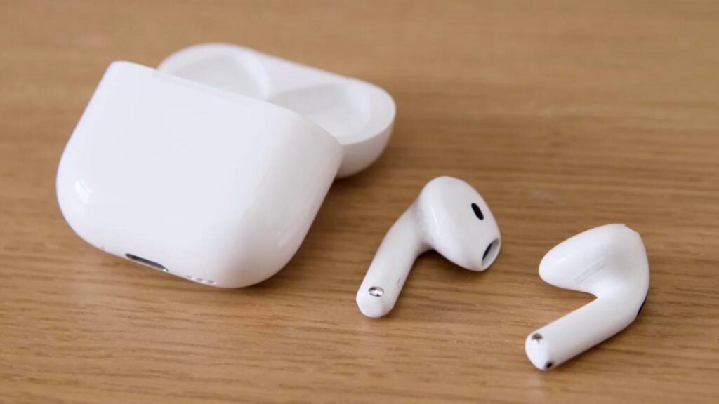 The AirPods Pro 4 ANC and their charing case on a wooden table 