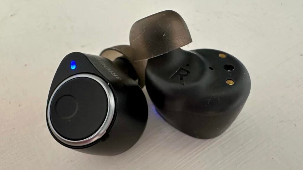 The Cambridge Audio Melomania M100 wireles earbuds on a white table