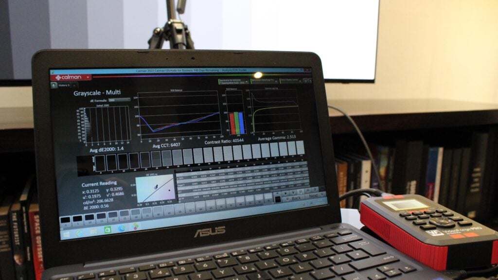 A laptop with Calman calibration software running and a pattern generator connected to a TV being tested