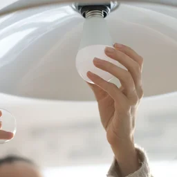 Someone changing a light bulb