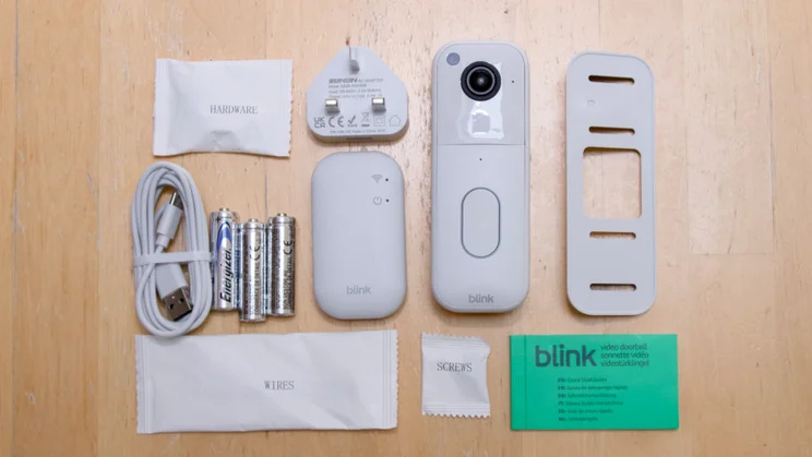 The Blink Video Doorbell 2nd generation and box contents arrayed on a pale wood table