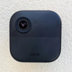 Front view of the Blink Outdoor 4 camera mounted on a white wall