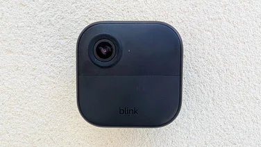 Front view of the Blink Outdoor 4 camera mounted on a white wall