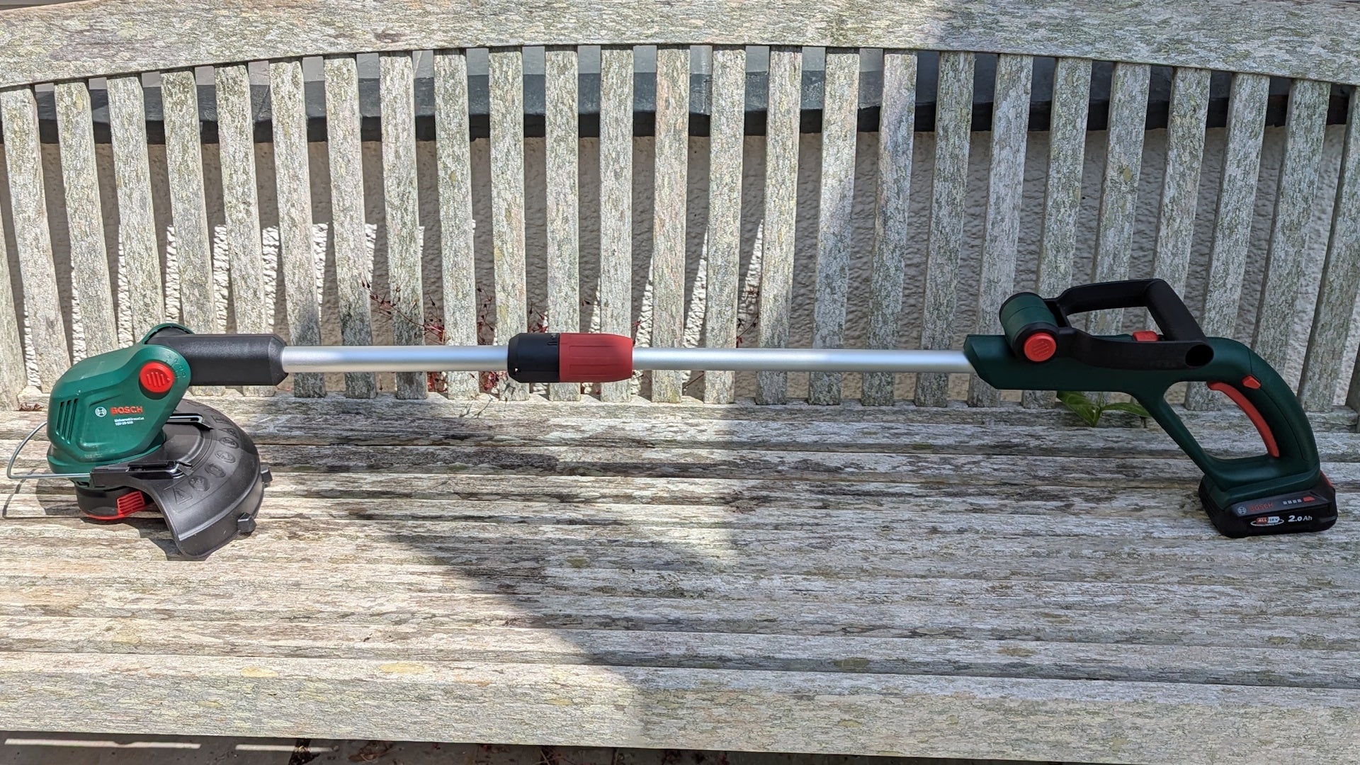 Bosch UniversalGrassCut 18V-26-500 on a wooden bench