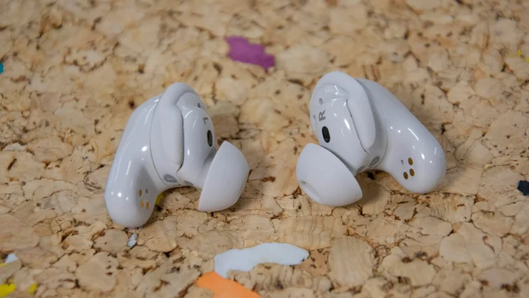 The Bose QuietComfort Ultra Earbuds 2nd Gen on a cork table with their eartips and stability bands clearly on show