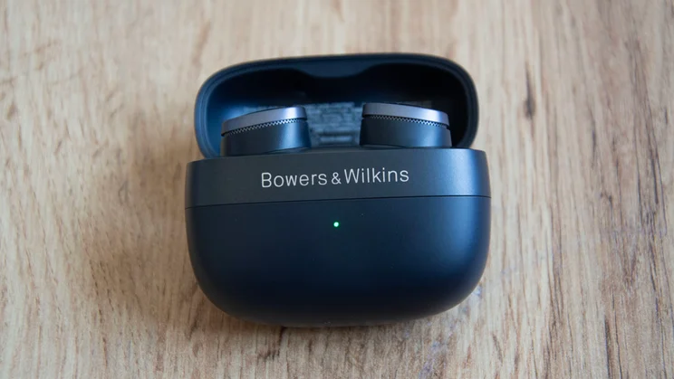 Image of the Bowers & Wilkins Pi8 in their case lying on a table with the lid open