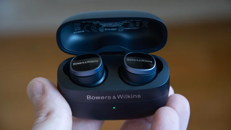 Image of the Bowers & Wilkins Pi8 in their case being held with the lid open