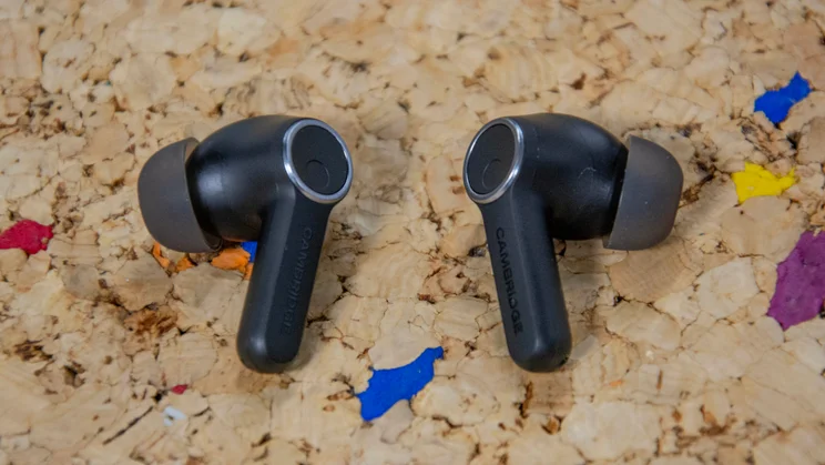 The Cambridge Audio Melomania A100 wireless earbuds on a cork table with their eartips facing outwards