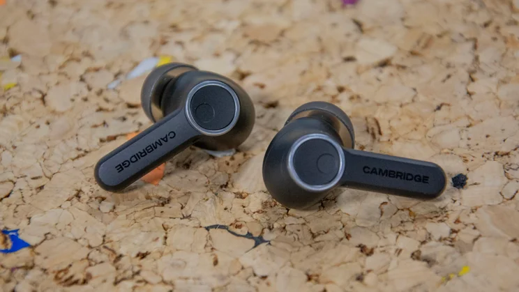 The Cambridge Audio Melomania A100 wireless earbuds on a cork table