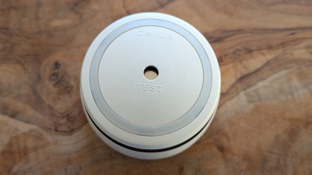 The Cavius CV2106 smoke alarm pictured from above on a wood surface