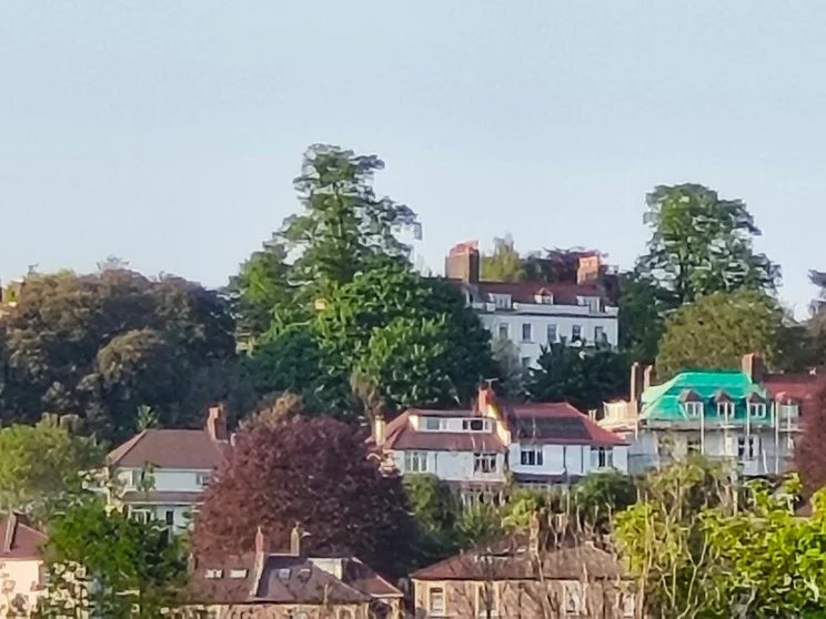 20x hybrid zoom shot of houses surrounded by trees