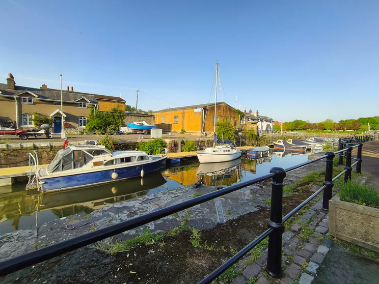 Wide-angle shot of a river with a boat moored upon it