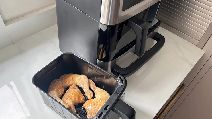 Cooked chicken in a drawer of the Cuisinart Tri Zone 13.6l Air Fryer & Oven, on a kitchen worktop