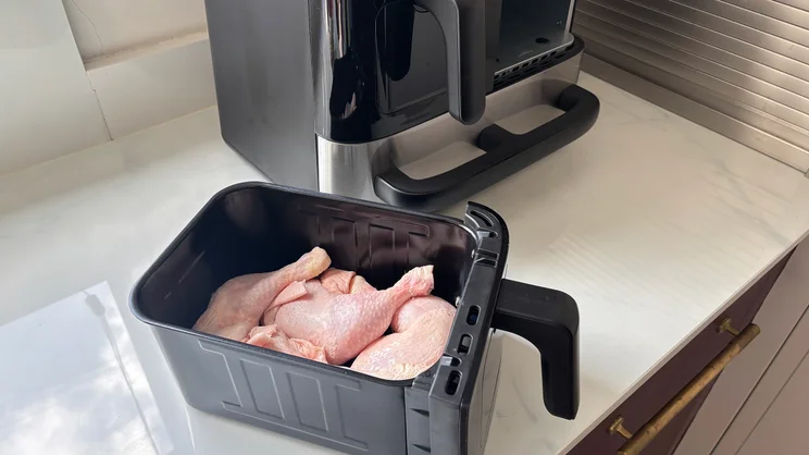 Raw chicken legs inside one of the Cuisinart Tri Zone 13.6l Air Fryer & Oven's drawers