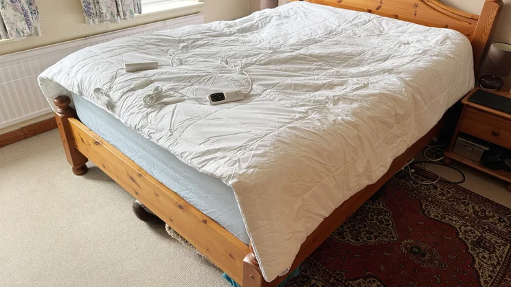 The Dreamland Love Mornings Heated Duvet laid on top of a mattress in a bedroom