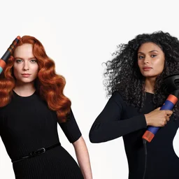 Two women with different hair textures using the curling and diffusing attachments for the new Dyson Airwrap i.d.