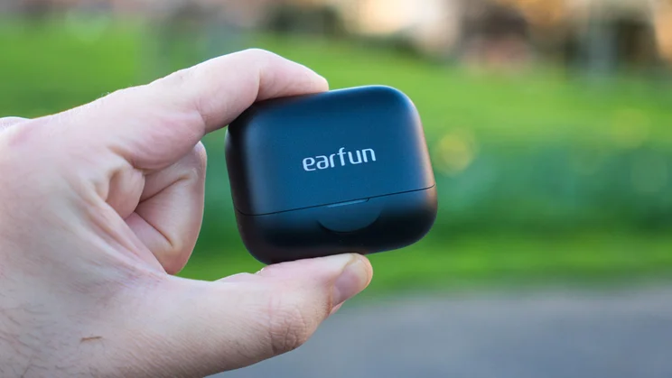 The charging case of the EarFun Air Pro 4+ wireless earbuds being held in a hand