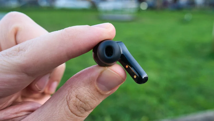 One of the EarFun Air Pro 4+ wireless earbuds being held in a hand to show the silicone eartip