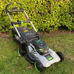 The Ego LM2236E-SP lawn mower on a lawn, in front of a hedge