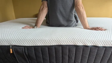 Emma NextGen Cooling mattress with man sat on top