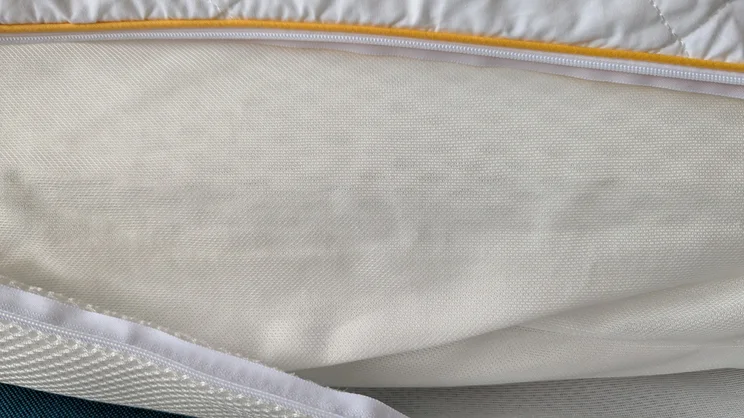 A closeup of the Eve Hybrid Side Sleeper pillow, its uncovered unzipped to show its inside