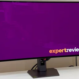 The Asus ROG Strix XG32UCWG pictured on a white desktop from a slight angle and to the left