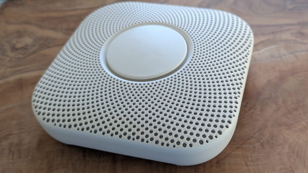 The Google Nest Protect 2nd Generation pictured on a wood table 