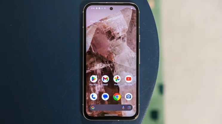 google pixel 8a review phone upright on desk with home screen